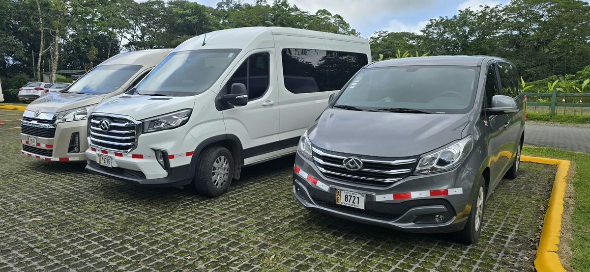 Three vehicles from our fleet parked: two white vans and a grey minivan